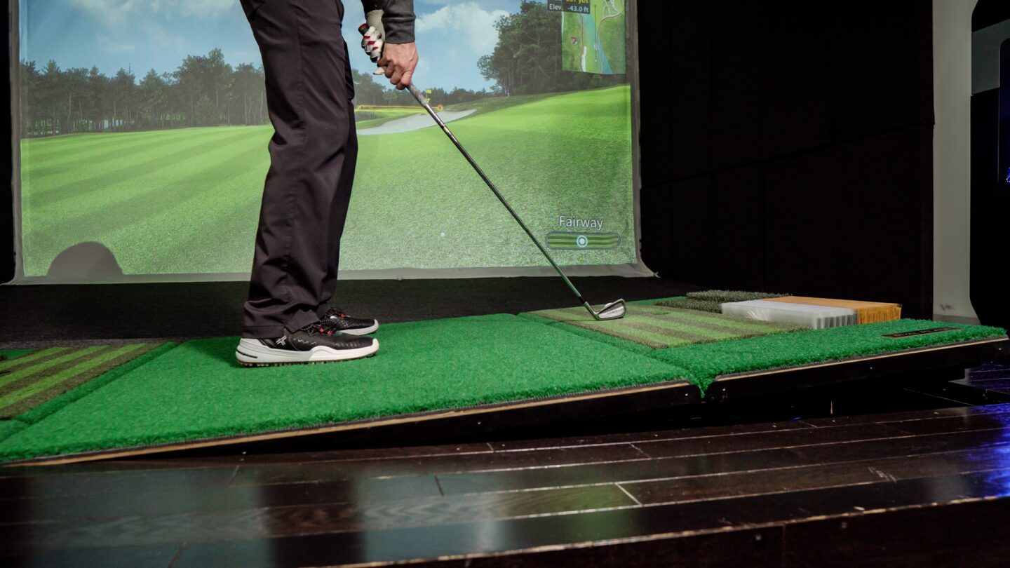 A golfer enjoying a private simulator bay