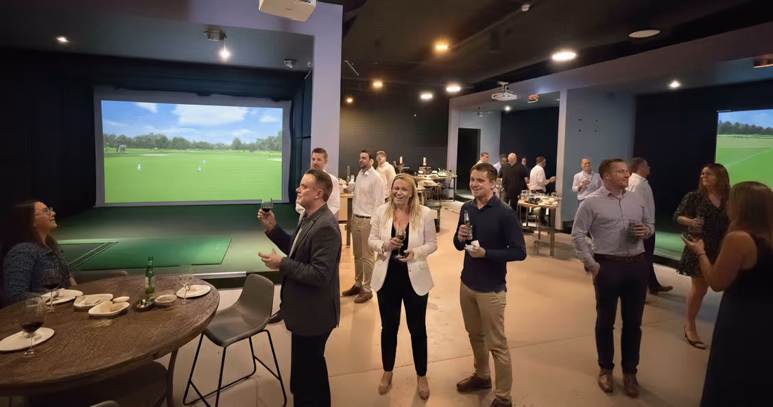 Friends laughing and enjoying drinks at Apex Golf Club